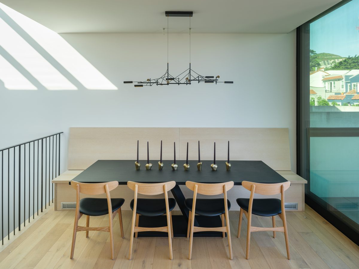 Dining table beneath a linear fixture