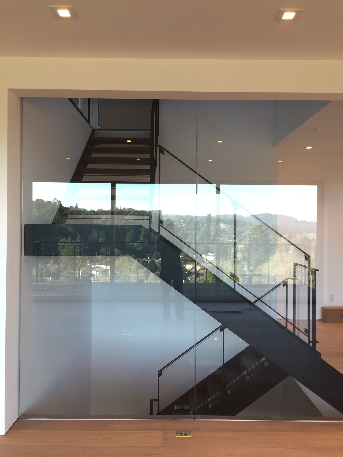 Steel stair behind a glass wall, with the valley beyond